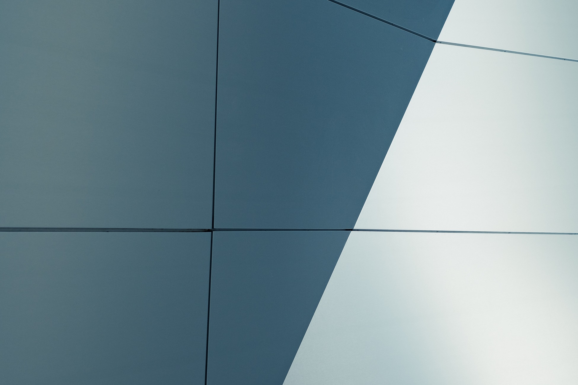 Geometric patterns of intersecting dark and light surfaces in a modern architectural design.