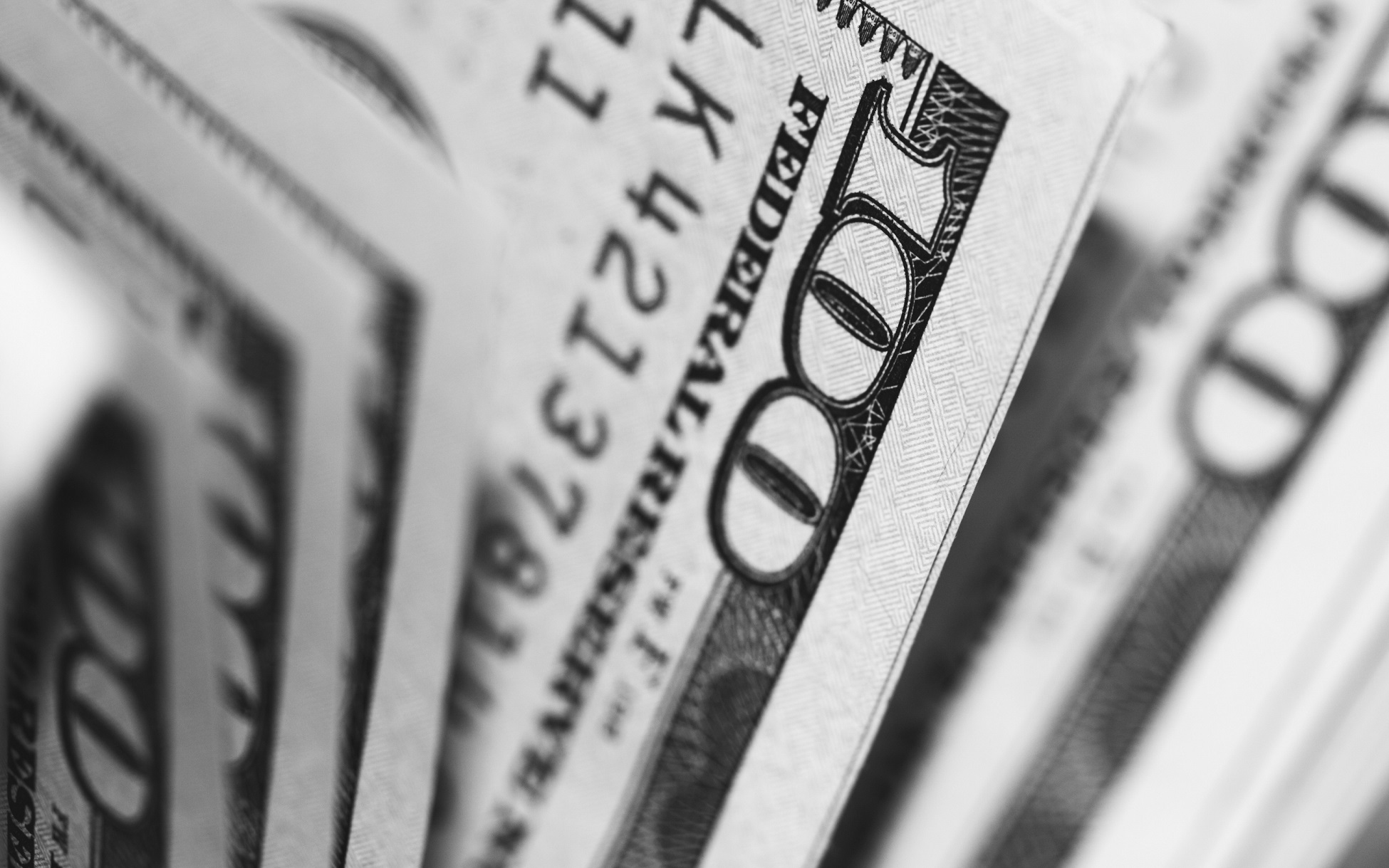 Close-up of stacked hundred-dollar bills arranged in a fan pattern.