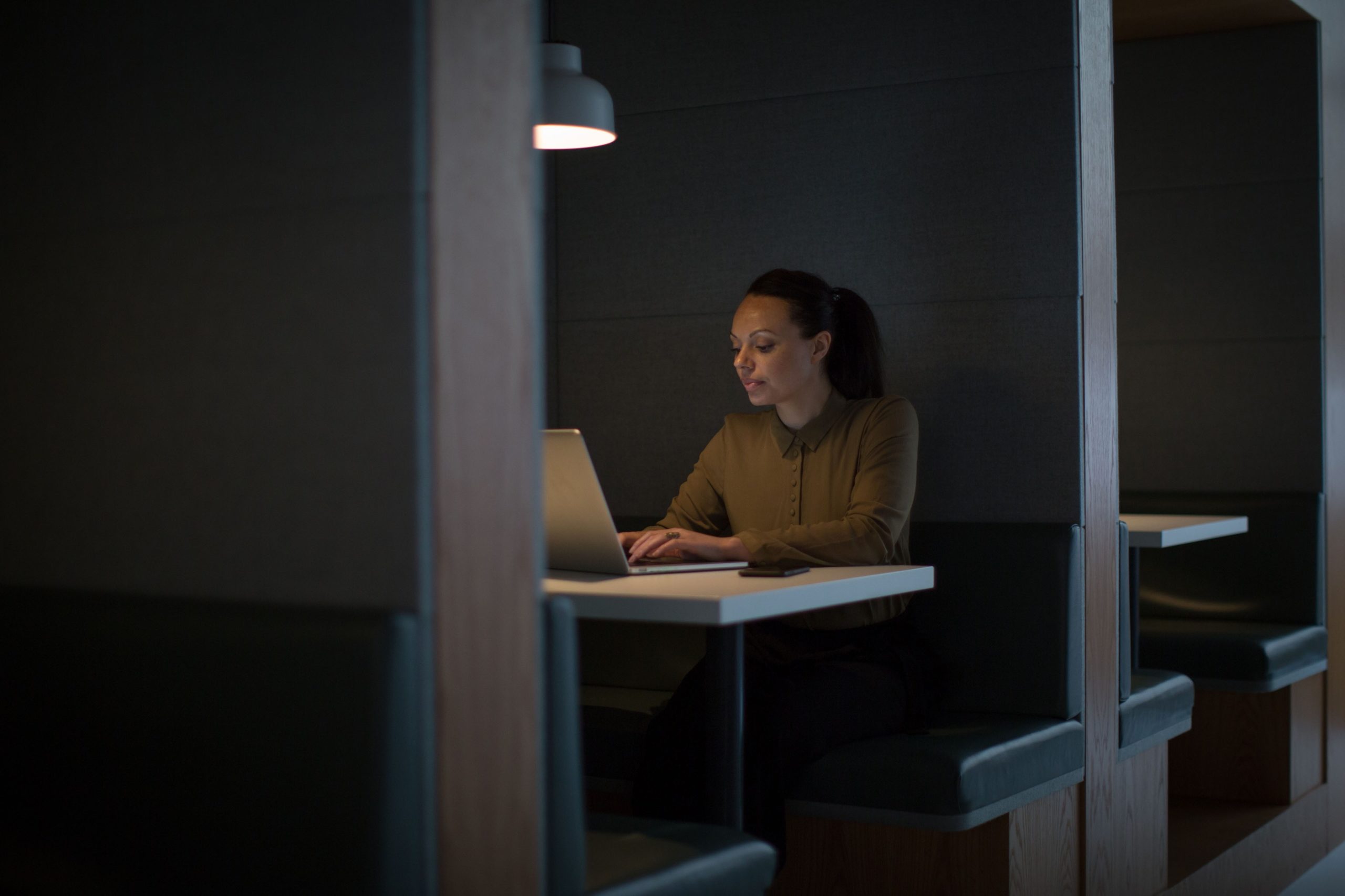 Professional reviewing information on a laptop in a modern workspace.