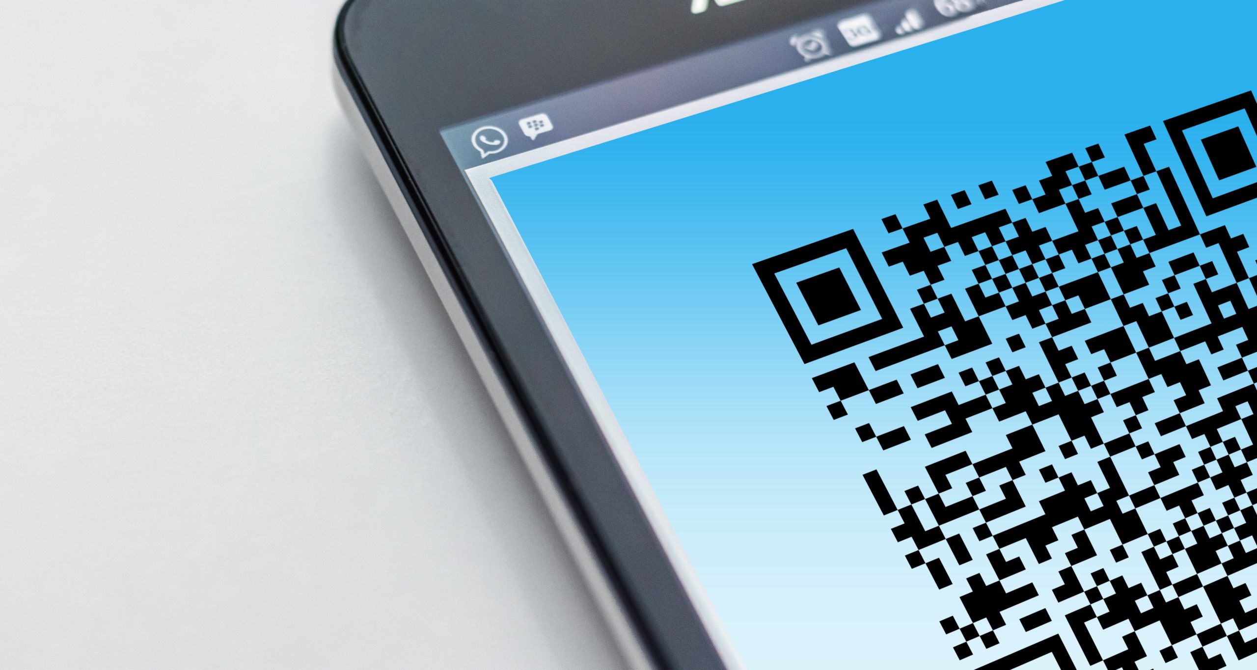 Mobile phone displaying a QR code on a blue background.