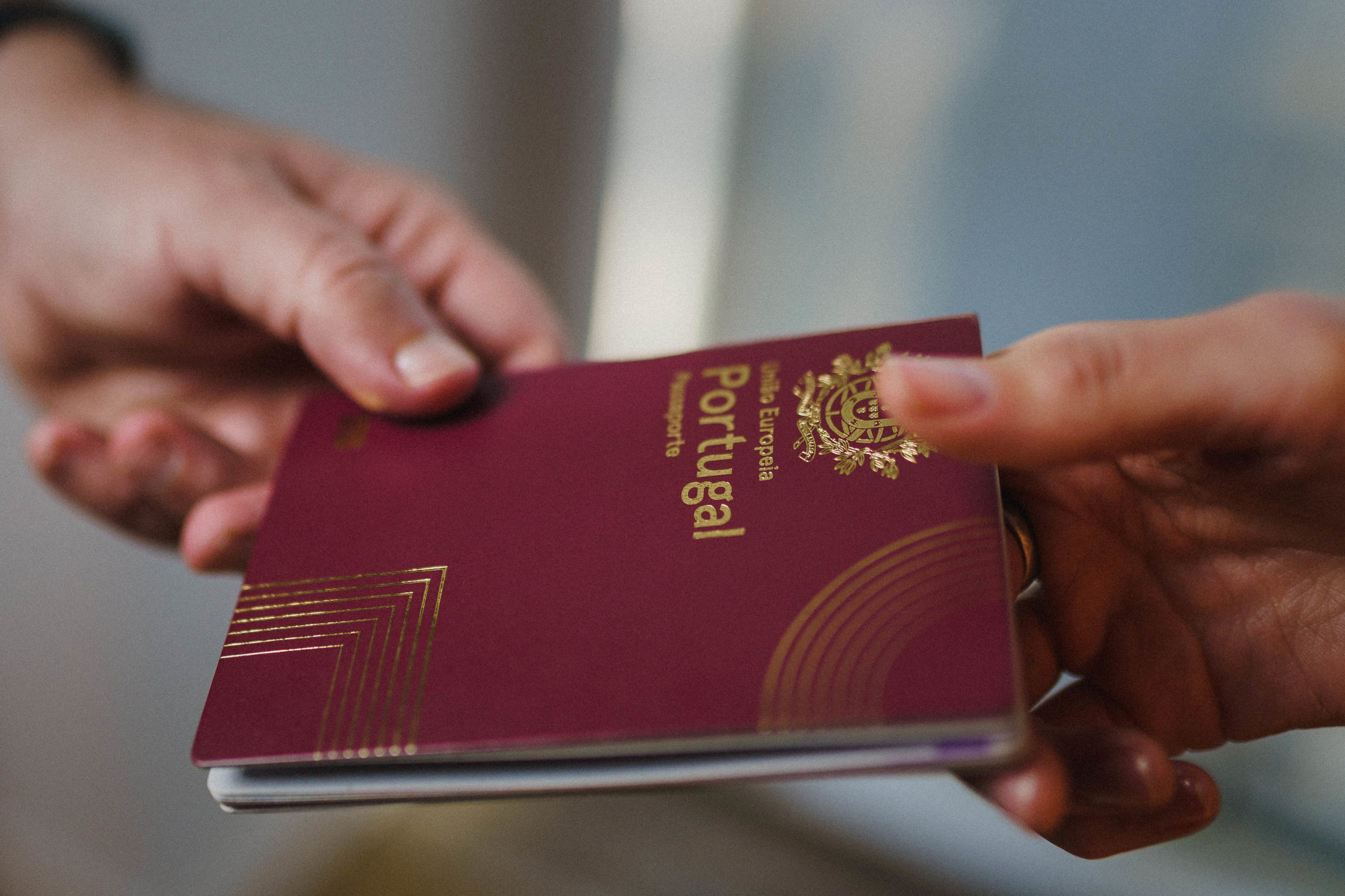 Hands exchanging a passport, highlighting the act of document verification or transfer in a legal context.