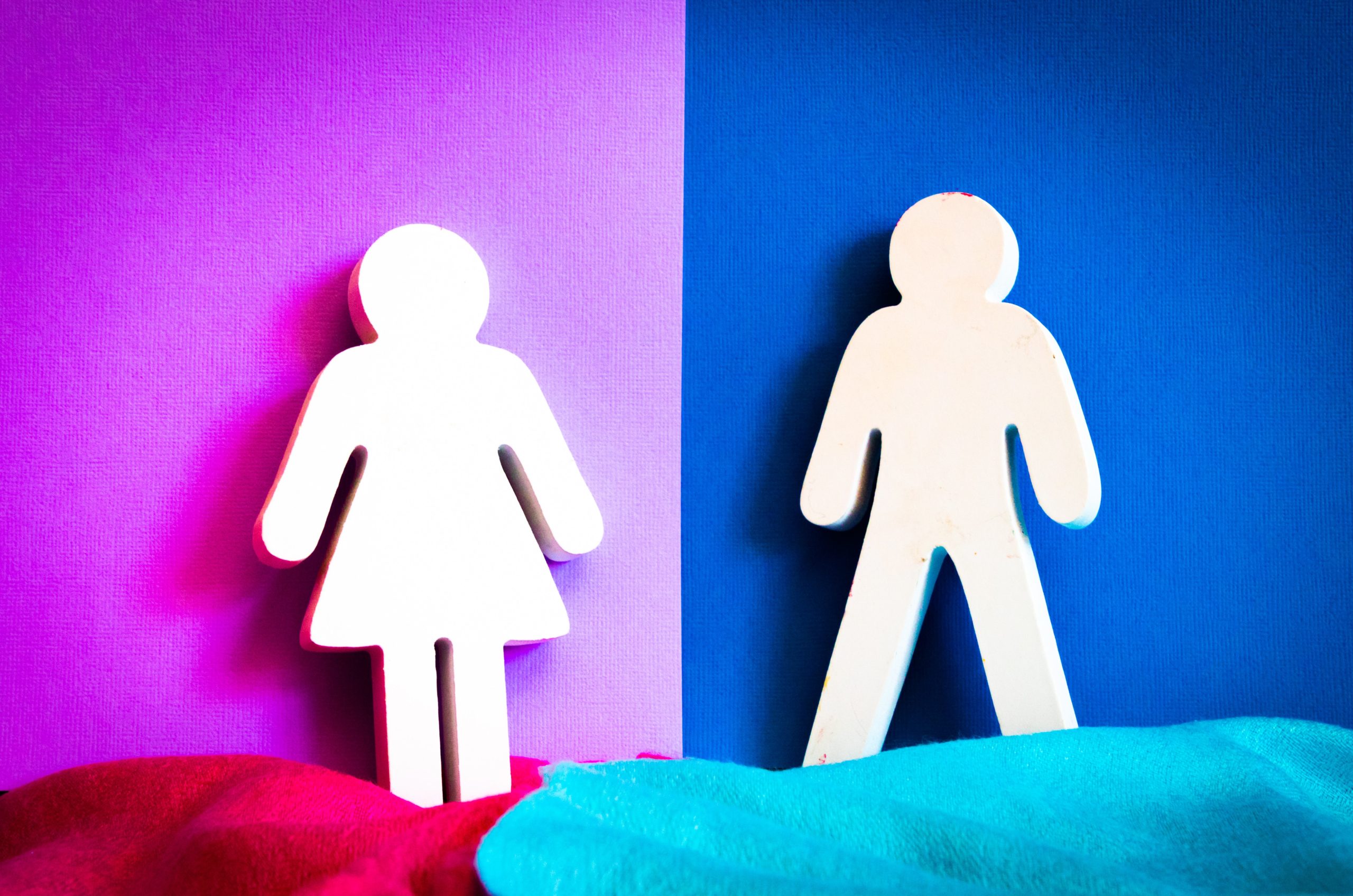 Two gender symbols, one female and one male, positioned against contrasting purple and blue backgrounds.