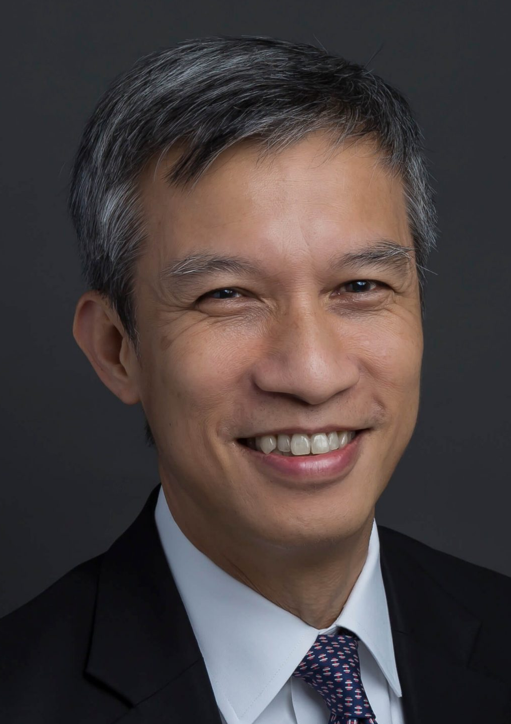 Professional Smiling Male Attorney In A Suit Against A Neutral Background.
