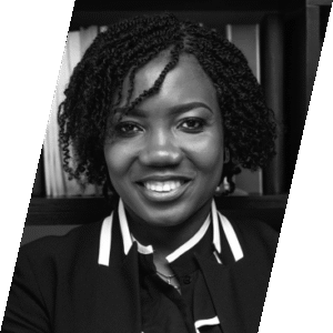 Attorney smiling in front of a bookshelf filled with legal texts.