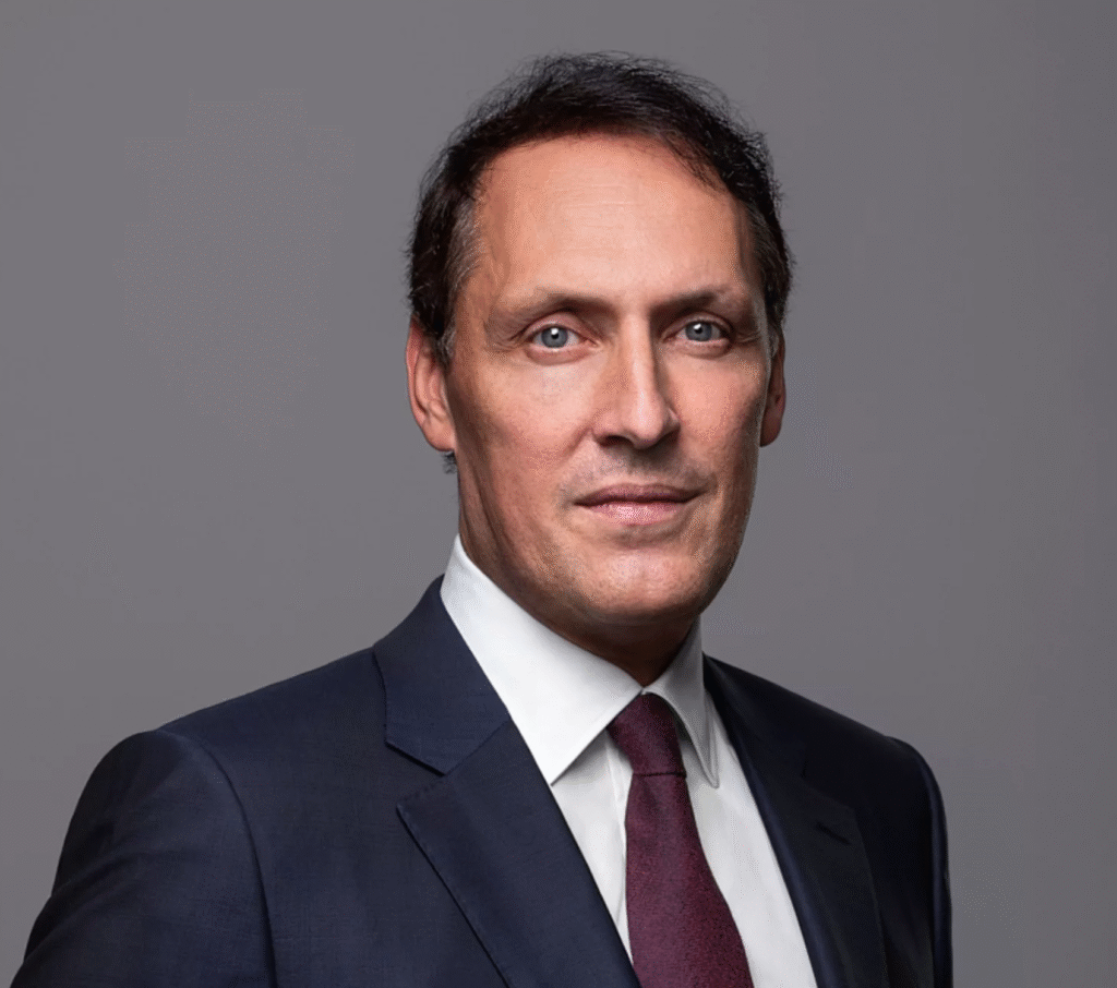 Attorney in a suit displaying a professional demeanor against a neutral background.