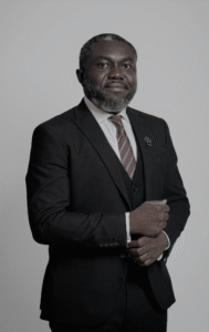 Lawyer in a suit with a serious expression, standing confidently against a neutral background.