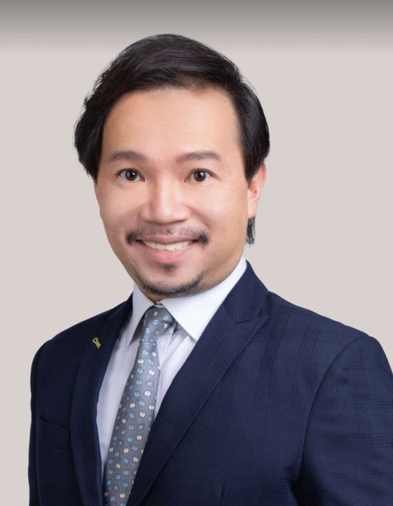 Attorney in a business suit smiling against a neutral background.
