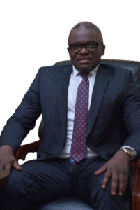 Lawyer seated in an office chair, wearing glasses and a suit, with a confident expression.