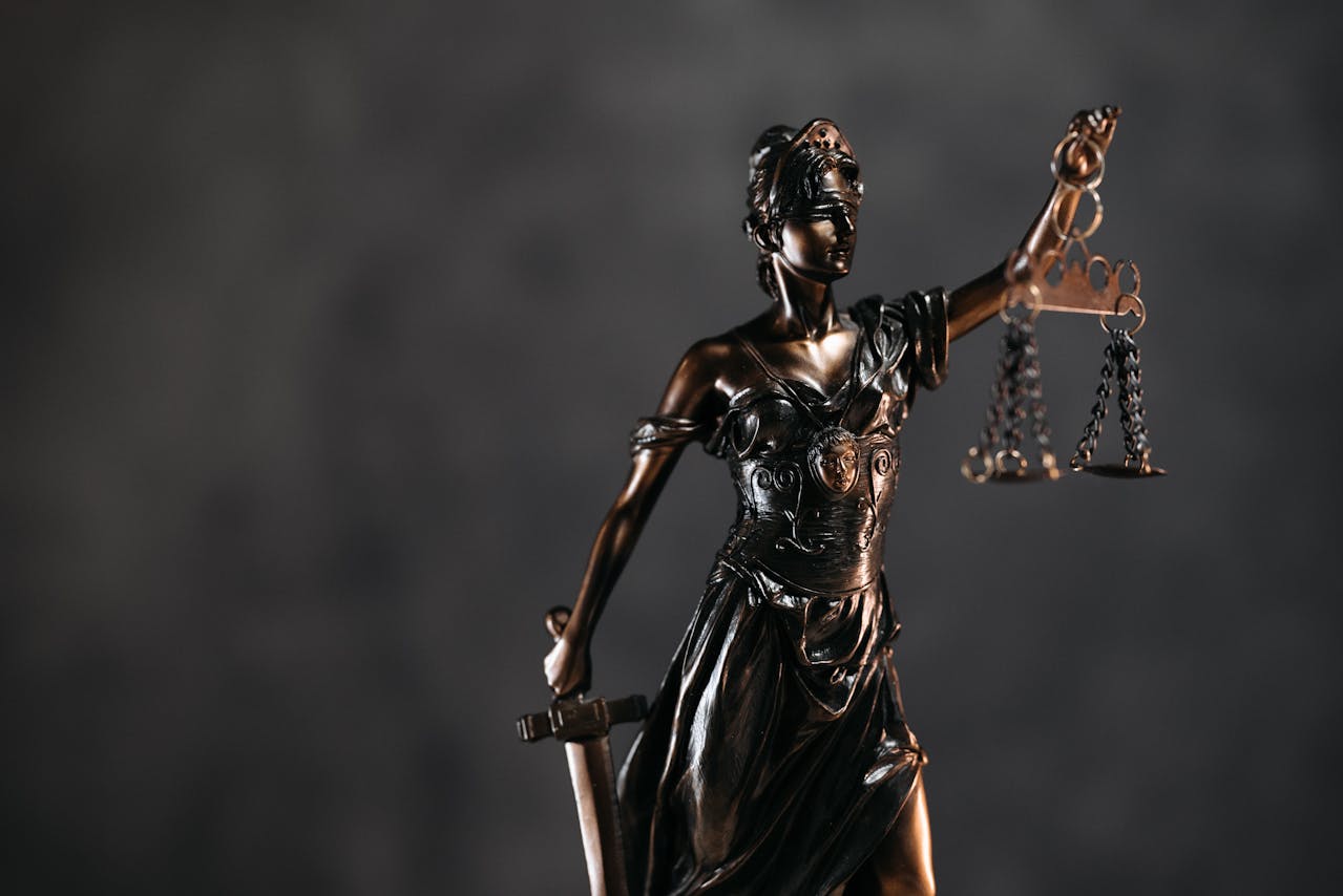 Bronze statue of Lady Justice holding scales and a sword, symbolizing fairness and the legal system.