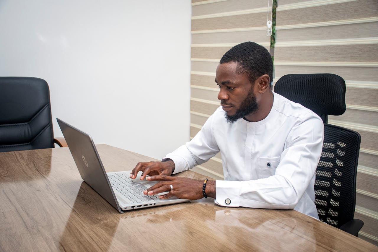 Legal professional typing on a laptop at a conference table in a law office setting.