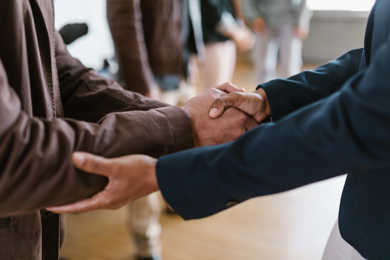 Attorney and client shaking hands in a professional setting.