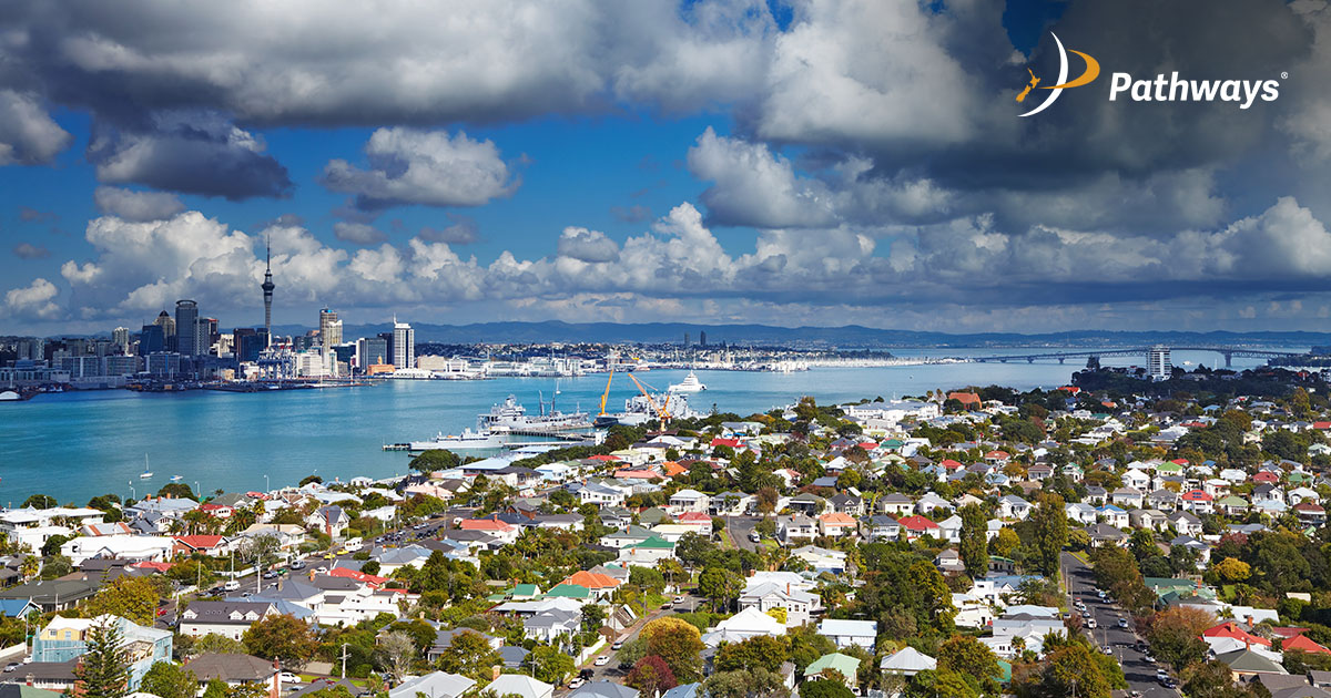 Skyline view of a city by the water, featuring waterfront buildings and boats along the shore.