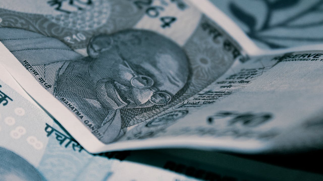 Currency notes featuring Mahatma Gandhi with visible denominations and intricate designs on a textured surface.