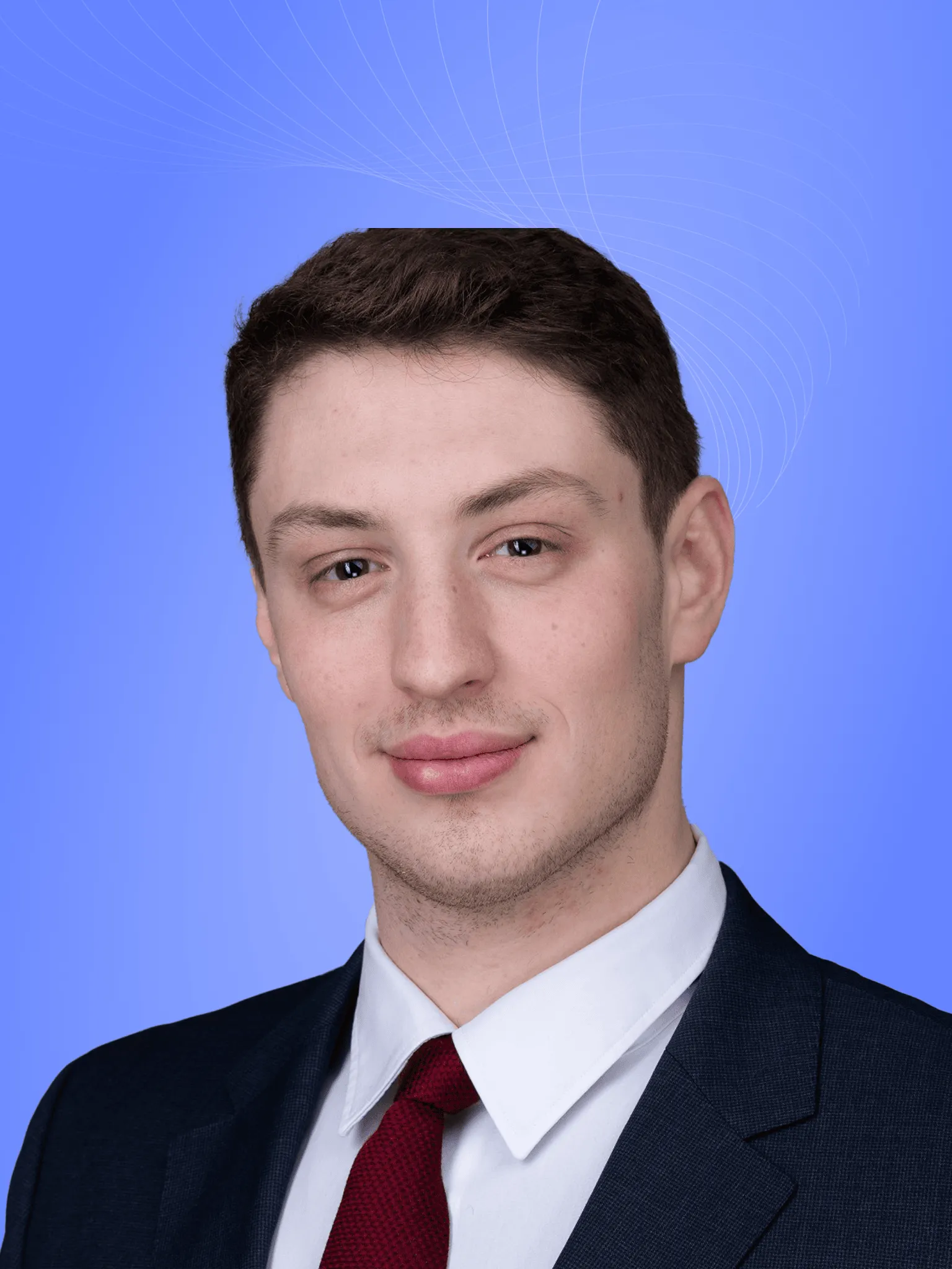 Lawyer in formal suit against a blue background, displaying a professional demeanor and confident expression.