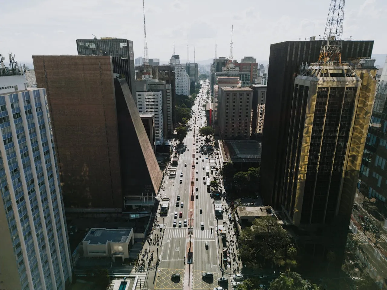 Cityscape with high-rise buildings, street traffic, and pedestrians in a bustling urban environment.