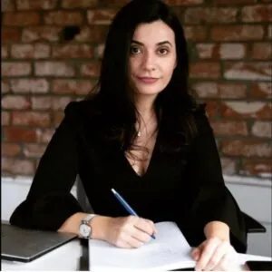 Lawyer writing notes and reviewing documents at a desk in a professional office setting.