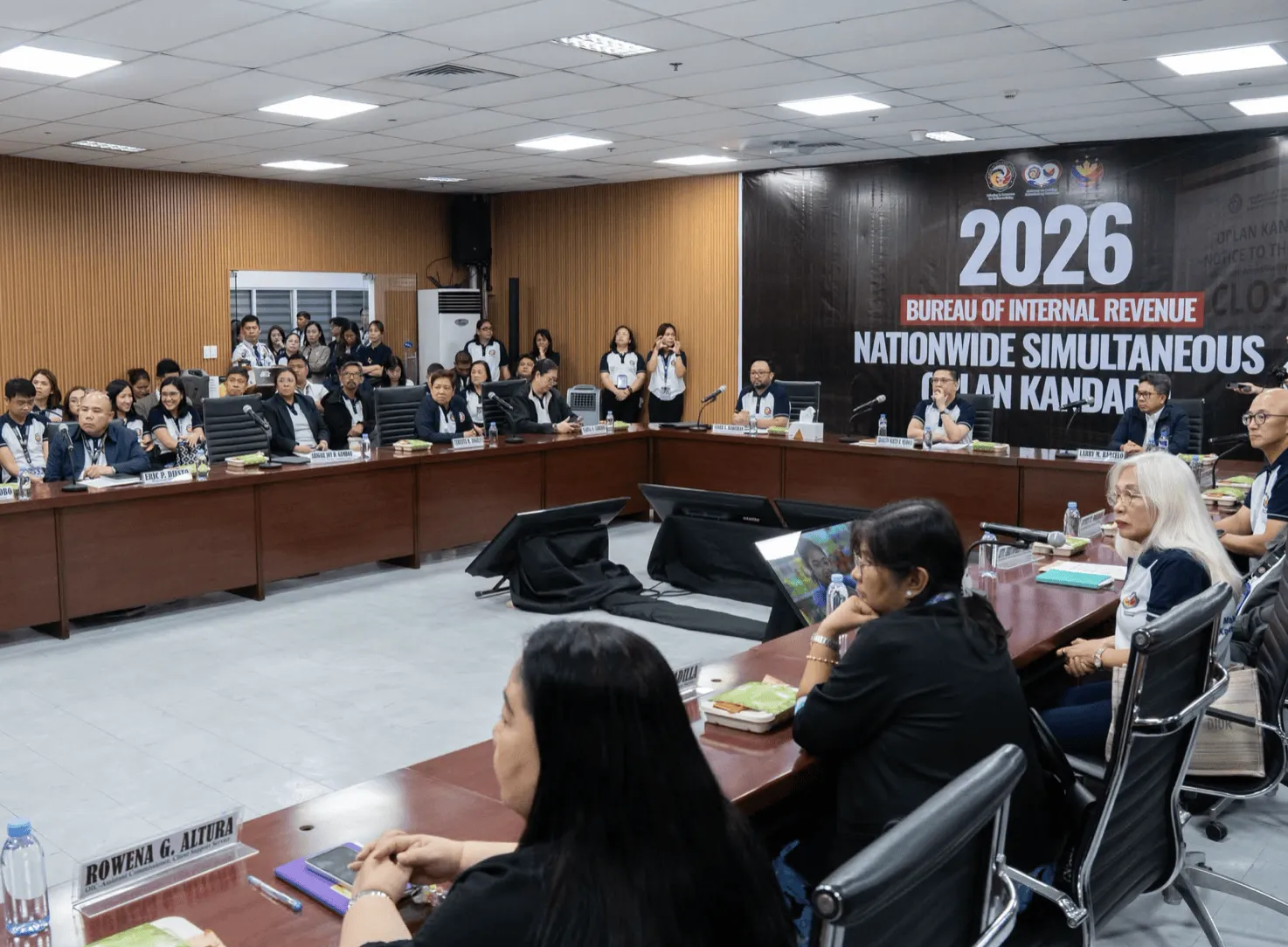 Group of legal professionals attending a seminar at a conference table in a meeting room.
