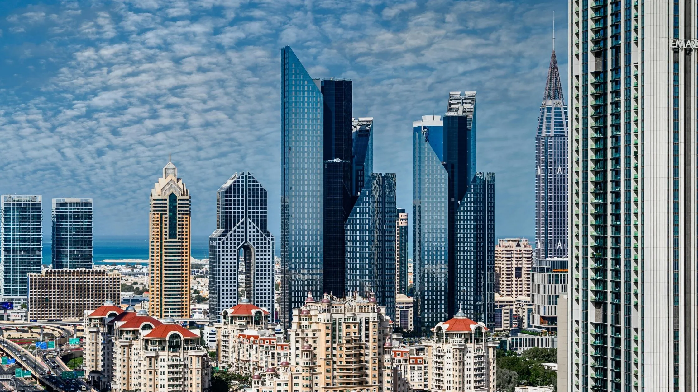 City skyline featuring modern skyscrapers with a mix of residential and commercial buildings.