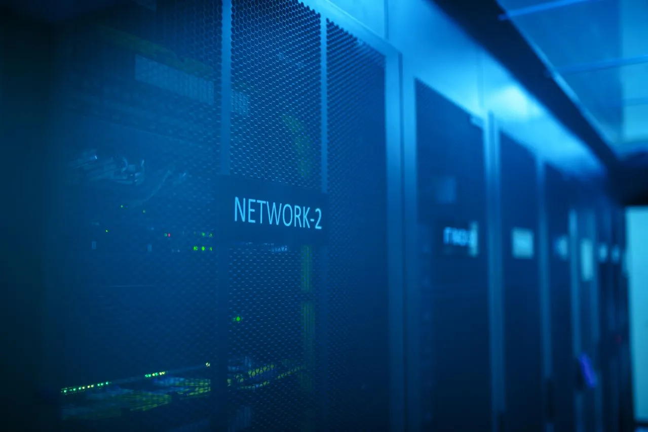 Server racks inside a data center, labeled NETWORK-2, with illuminated components and a blue lighting ambiance.