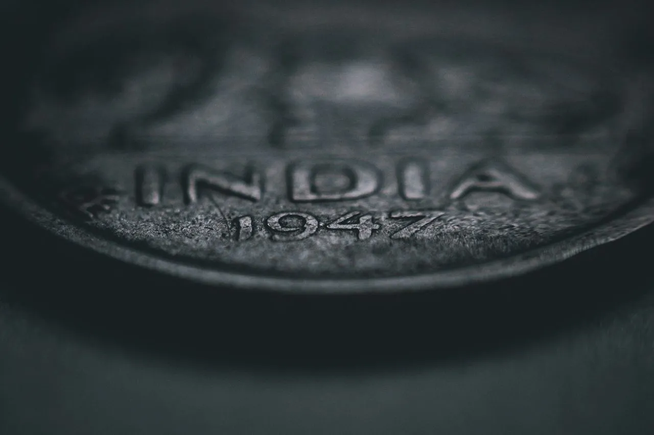 Close-up of a 1947 Indian coin showing the word "INDIA" prominently.
