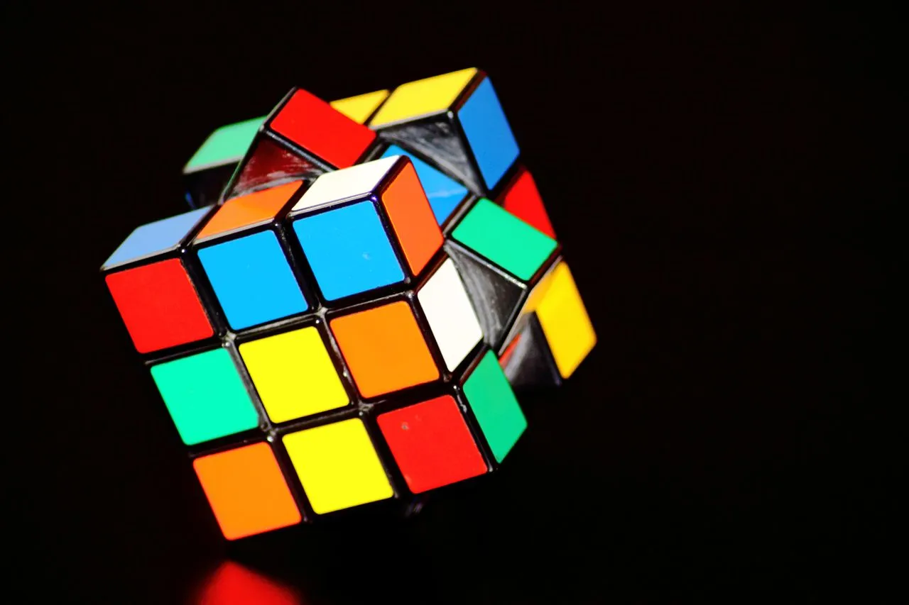 Colorful Rubik's Cube in a partially rotated position against a dark background.