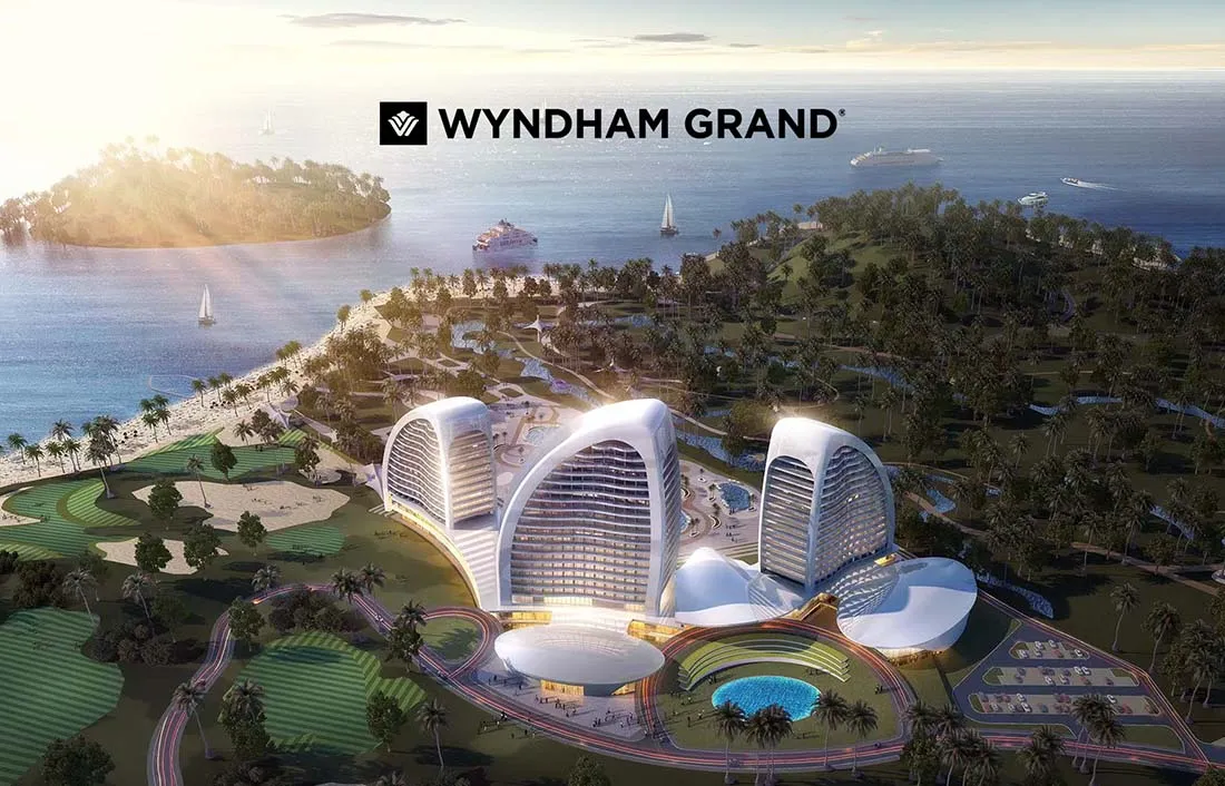 Resort complex by the ocean featuring modern architecture, pool, and landscaped grounds with palm trees.