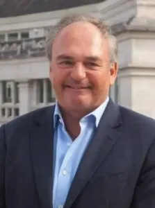 Lawyer smiling while standing outdoors in front of a modern building.