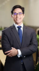 Attorney standing confidently with arms crossed in a professional office setting.