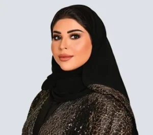 Professional woman wearing a black hijab, posing confidently against a neutral background.