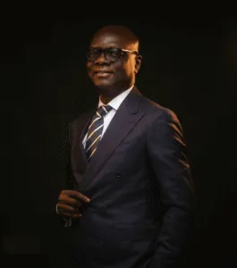 Attorney dressed in a dark suit and glasses, posing confidently against a dark background.