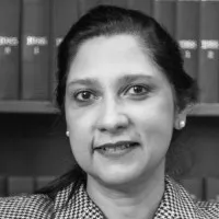 Attorney posing for a portrait with law books in the background, showcasing a professional legal presence.